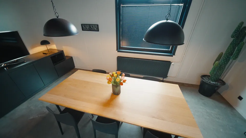 Meeting room with a large wooden table and pendant lamps